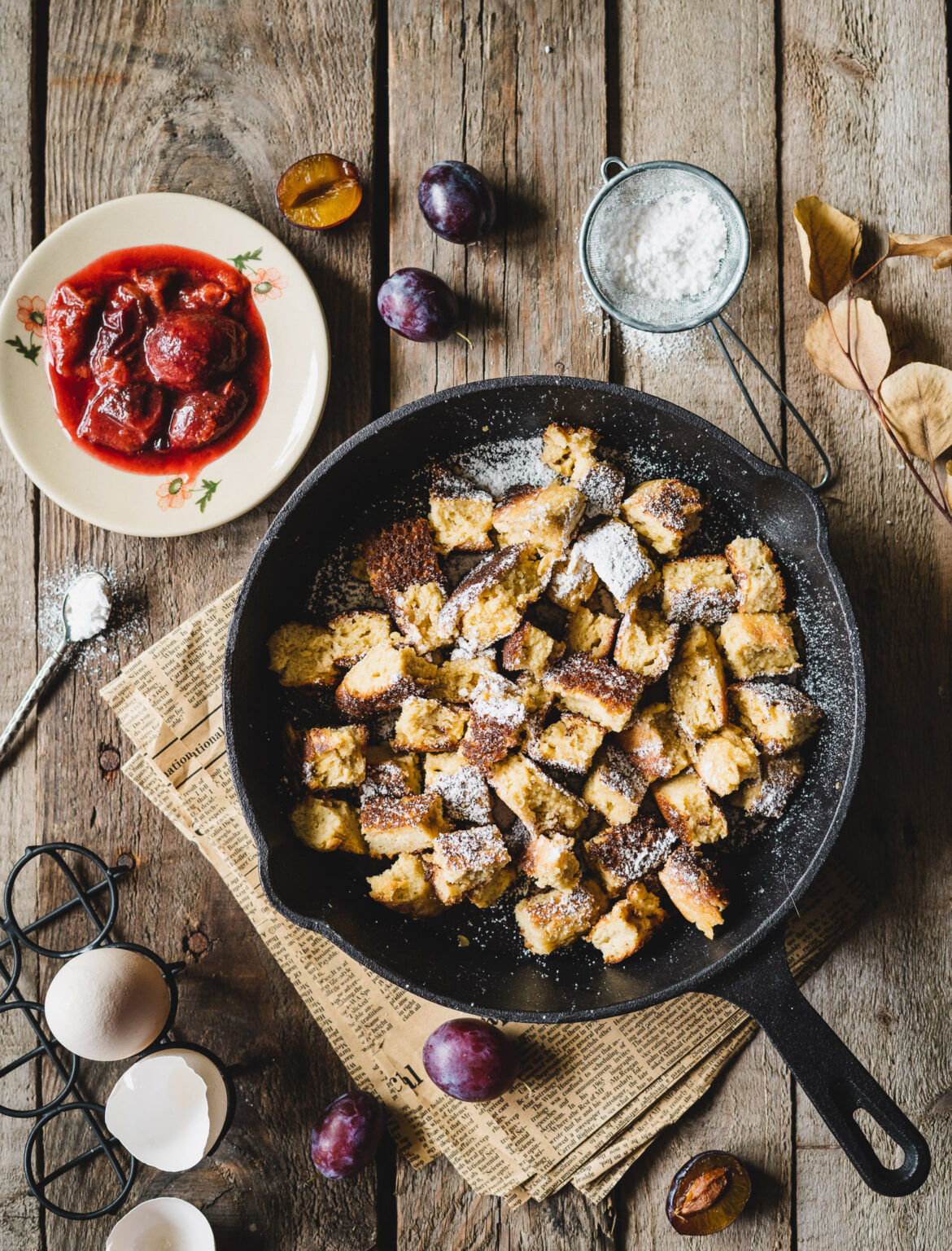 omlet cesarski, posypany cukrem pudrem, ze smażonymi śliwkami
