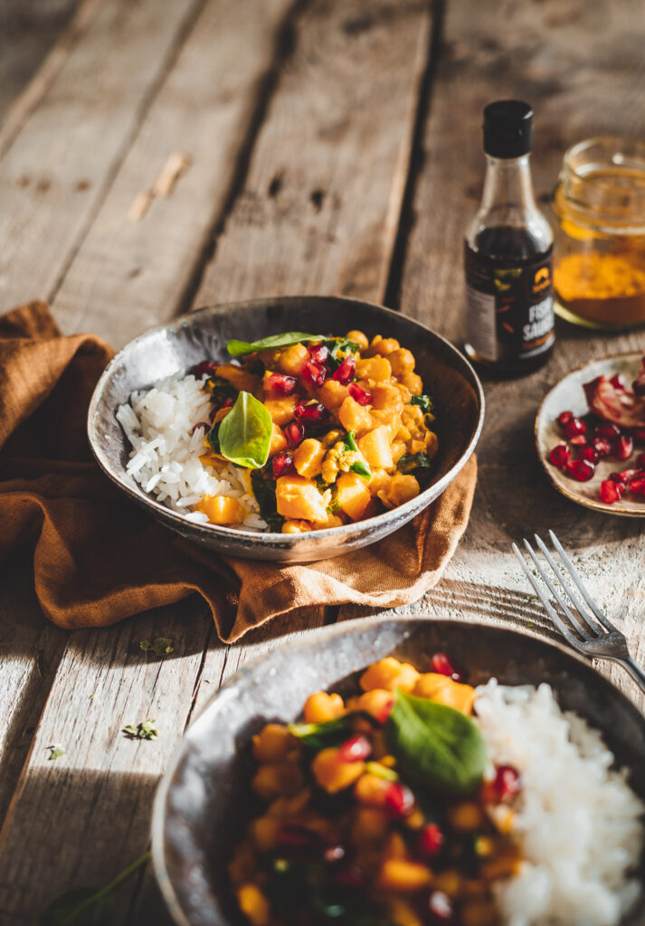 curry z ciecierzycą i dynią, szpinakiem oraz granatem.
