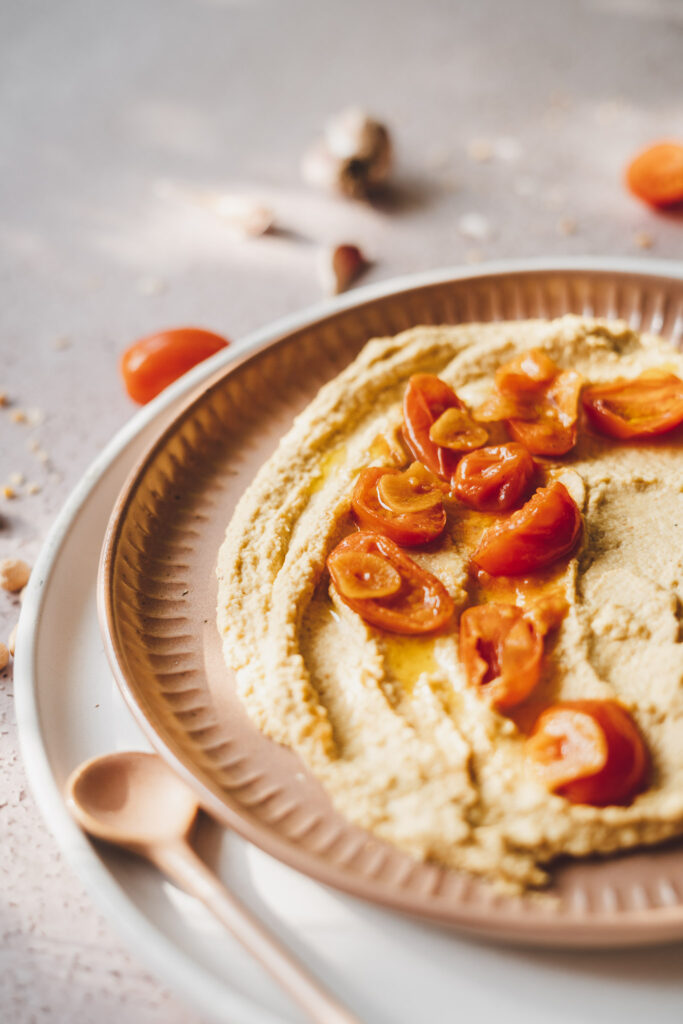 hummus ze smażonymi pomidorkami koktajlowymi z plasterkami czosnku, polany oliwą z oliwek