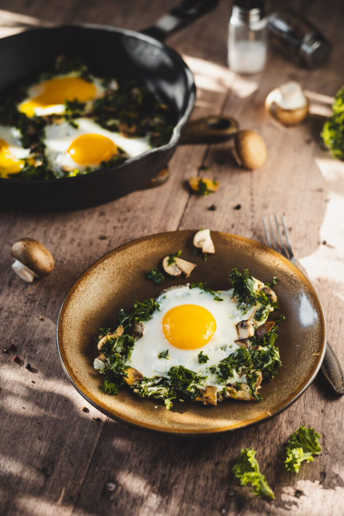 jajka sadzone na jarmużu z dodatkiem pieczarek smażone na patelni