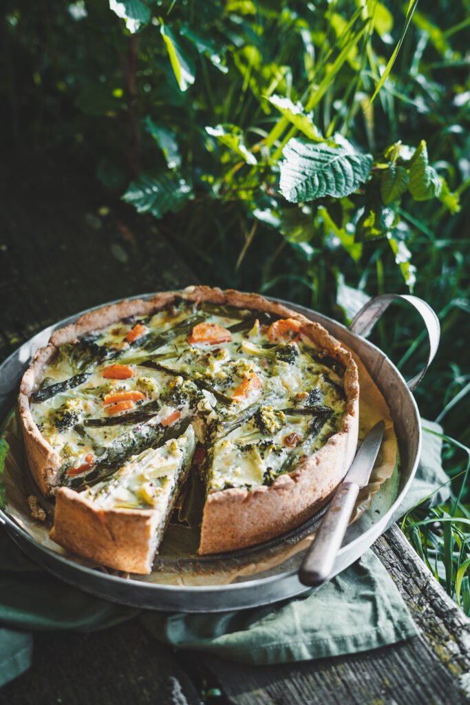 Quiche ze szparagami i brokułem podany na tacy