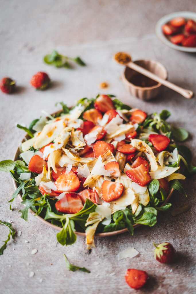 sałatka z truskawkami i pieczonym fenkułem polana musztardowym dressingiem, na talerzu.